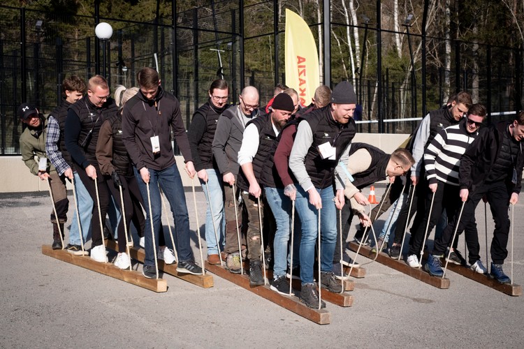 Teambuilding, ett gäng människor balanserar på träplankar som de ska gå fram på tilsammans