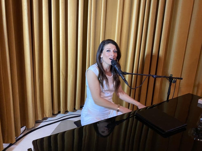 Kvinna framträder på digitalt event genom att sjunga och spela piano